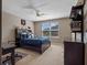 Bedroom with carpet, ceiling fan, desk, dresser and large window at 14172 Hutchinson St, Winter Garden, FL 34787