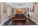 Elegant dining room with tray ceiling, hardwood floors, and a stylish chandelier over a large table at 14172 Hutchinson St, Winter Garden, FL 34787