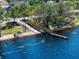 A wooden dock leads to the edge of a blue lake surrounded by mature trees and foliage at 14172 Hutchinson St, Winter Garden, FL 34787