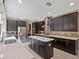 Modern kitchen with dark wood cabinets, stainless steel appliances, and a kitchen island at 14172 Hutchinson St, Winter Garden, FL 34787