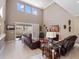 Bright living room with two-story ceilings, large windows, and leather reclining sofas at 14172 Hutchinson St, Winter Garden, FL 34787