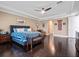 Open main bedroom with dark hardwood floors, a blue upholstered bed frame, and a light color pallete at 14172 Hutchinson St, Winter Garden, FL 34787