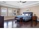 Large main bedroom featuring a dark wood floor, a blue upholstered bed frame, and a ceiling fan at 14172 Hutchinson St, Winter Garden, FL 34787