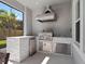 Modern outdoor kitchen with stainless steel grill, sink, mini fridge and a white brick backsplash at 14172 Hutchinson St, Winter Garden, FL 34787