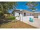 Backyard patio with a blue chair, enclosed by a fence with a view of the home's exterior at 1607 India Palm Dr, Edgewater, FL 32132