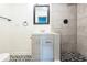 Modern bathroom featuring a vanity with gray drawers, black hardware and mirror, and decorative tile flooring at 1607 India Palm Dr, Edgewater, FL 32132