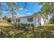 Charming single-story home featuring white brick, dark shutters, and tasteful landscaping at 1607 India Palm Dr, Edgewater, FL 32132