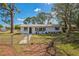 Charming exterior view of the property featuring a well-maintained lawn and a white painted brick facade at 1607 India Palm Dr, Edgewater, FL 32132