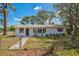 Charming exterior view of the property featuring a well-maintained lawn and a white painted brick facade at 1607 India Palm Dr, Edgewater, FL 32132