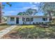 Charming one-story white brick home with well-maintained landscaping and a walkway leading to the front door at 1607 India Palm Dr, Edgewater, FL 32132