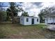 Small storage shed in the backyard with a simple design and a black front door at 1607 India Palm Dr, Edgewater, FL 32132