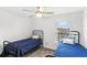 Comfortable bedroom with a ceiling fan, natural light from window, and cozy twin beds at 1696 Tohoqua Blvd, Kissimmee, FL 34744
