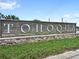 Community signage with stone base and green landscaping on a sunny day at 1696 Tohoqua Blvd, Kissimmee, FL 34744