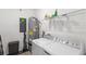 Well-equipped laundry room with washer, dryer, and storage shelves at 1696 Tohoqua Blvd, Kissimmee, FL 34744