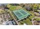 Aerial view of community tennis courts, bordered by trees and landscaping, near a clubhouse and residential area at 1696 Tohoqua Blvd, Kissimmee, FL 34744