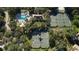 Attractive aerial view of tennis courts and swimming pool surrounded by trees in a residential neighborhood at 1707 Stetson Ct, Longwood, FL 32779