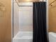 Bathroom featuring tiled walls and a bathtub with black shower curtain at 1707 Stetson Ct, Longwood, FL 32779