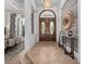 Grand foyer featuring a decorative front door, tile flooring, and elegant light fixture at 1707 Stetson Ct, Longwood, FL 32779