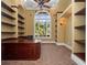 Stylish home office with built-in shelving and a large arched window with a view of lush landscaping at 1707 Stetson Ct, Longwood, FL 32779