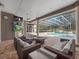 Outdoor pool area with multiple seating areas, a fireplace, and a screened-in ceiling at 1707 Stetson Ct, Longwood, FL 32779