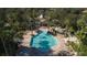 A beautiful swimming pool with pristine blue water, surrounded by palm trees and a brick patio at 1707 Stetson Ct, Longwood, FL 32779