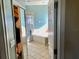 Bathroom with a garden tub, a separate glass shower enclosure, and light-colored tile flooring, from closet at 1838 Palmerston Cir, Ocoee, FL 34761