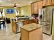 The kitchen features stainless steel appliances, wooden cabinets, and a central island with granite countertops at 1838 Palmerston Cir, Ocoee, FL 34761