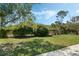 Fenced backyard featuring a lush green lawn and mature shrubs under a partially cloudy blue sky at 1873 Poinciana Rd, Winter Park, FL 32792