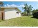 View of the home's backyard with green grass and partial fencing under a bright blue sky with a few clouds at 1873 Poinciana Rd, Winter Park, FL 32792