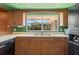 Kitchen featuring wood cabinets, solid countertops and a window looking out into the yard at 1873 Poinciana Rd, Winter Park, FL 32792