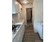 Galley kitchen featuring new cabinets and marble countertop with gray laminate flooring at 211 Cadillac Ct, Altamonte Springs, FL 32701
