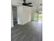 A spacious living room featuring sleek gray laminate flooring and a modern ceiling fan at 211 Cadillac Ct, Altamonte Springs, FL 32701