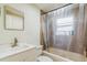 Bathroom with a vanity sink and a shower-tub combo featuring brown tile and natural light at 2204 Votaw Rd, Apopka, FL 32703