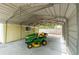 Metal carport featuring a yellow riding lawn mower to assist with yard maintenance at 2204 Votaw Rd, Apopka, FL 32703