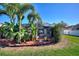 Lush backyard featuring tropical landscaping and a screened lanai at 222 Via Mariel E Dr, Davenport, FL 33896