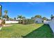 Spacious backyard with green lawn, mature trees, and a screened-in lanai at 222 Via Mariel E Dr, Davenport, FL 33896