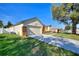 A view of the home's exterior, highlighting the well-maintained lawn and attached two-car garage at 222 Via Mariel E Dr, Davenport, FL 33896