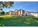Landscaped lawn with view of the home's front elevation, attached two-car garage, and fountain at 222 Via Mariel E Dr, Davenport, FL 33896