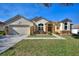 Charming single-story home with well-manicured lawn, landscaping, and inviting front fountain at 222 Via Mariel E Dr, Davenport, FL 33896