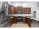 Modern kitchen with stainless steel appliances, granite countertops and dark wood cabinets at 222 Via Mariel E Dr, Davenport, FL 33896