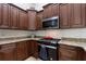 Close-up of the kitchen's stainless steel gas range, microwave, and granite countertops at 222 Via Mariel E Dr, Davenport, FL 33896