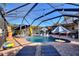 Sparkling pool with a water feature, umbrellas, and lounge chairs in the screened-in enclosure at 222 Via Mariel E Dr, Davenport, FL 33896