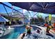 Screened-in pool area featuring a uniquely shaped pool, fountain, and outdoor lounge furnishings at 222 Via Mariel E Dr, Davenport, FL 33896