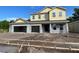 Two-story home featuring three-car garage and light yellow clapboard second story under a blue sky at 2430 Francisco Art Ct, Oviedo, FL 32765