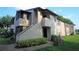 Exterior view of a two-story condo featuring neutral-colored walls, a screened-in porch, and well-maintained landscaping at 2936 Antique Oaks Cir # 71, Winter Park, FL 32792