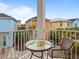 Charming balcony with seating area, offering a serene view of the colorful neighborhood architecture and lush greenery at 3095 Key Lime Loop, Kissimmee, FL 34747