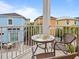 Balcony with seating offers a view of colorful neighborhood homes and lush landscaping at 3095 Key Lime Loop, Kissimmee, FL 34747