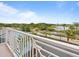 Inviting balcony view overlooking lush landscaping, and the lake beyond the road, creating a serene outdoor living space at 3095 Key Lime Loop, Kissimmee, FL 34747