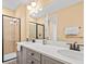 Elegant bathroom with dual sinks, a glass-enclosed shower and modern fixtures at 3095 Key Lime Loop, Kissimmee, FL 34747