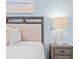 Bedroom detail showcasing bedside table with a decorative lamp and beach-themed art at 3095 Key Lime Loop, Kissimmee, FL 34747